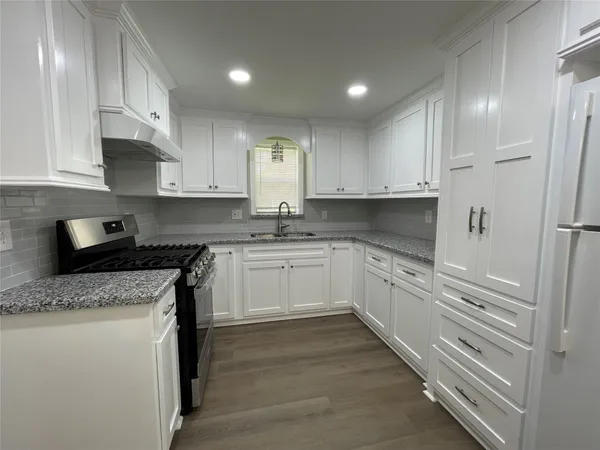a kitchen with granite countertop white cabinets and white appliances