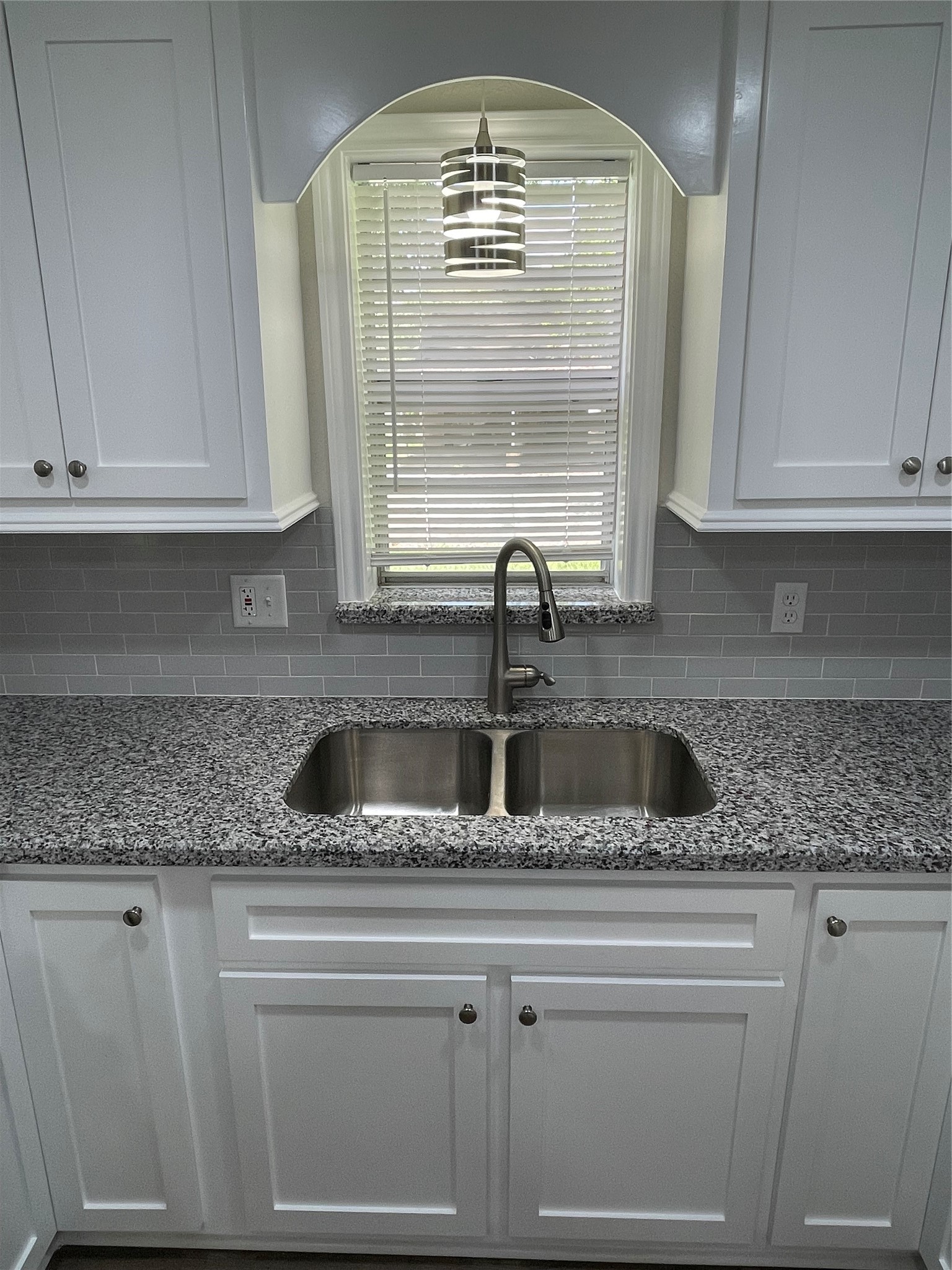 309 Ryan Street Angleton, TX 77515 - Photo 9 of 28 a kitchen with granite countertop a sink window and cabinets
