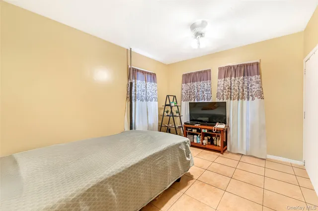 a spacious bedroom with a bed and a flat screen tv