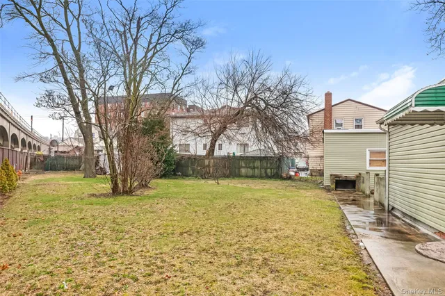 a view of a yard with a house and a large tree