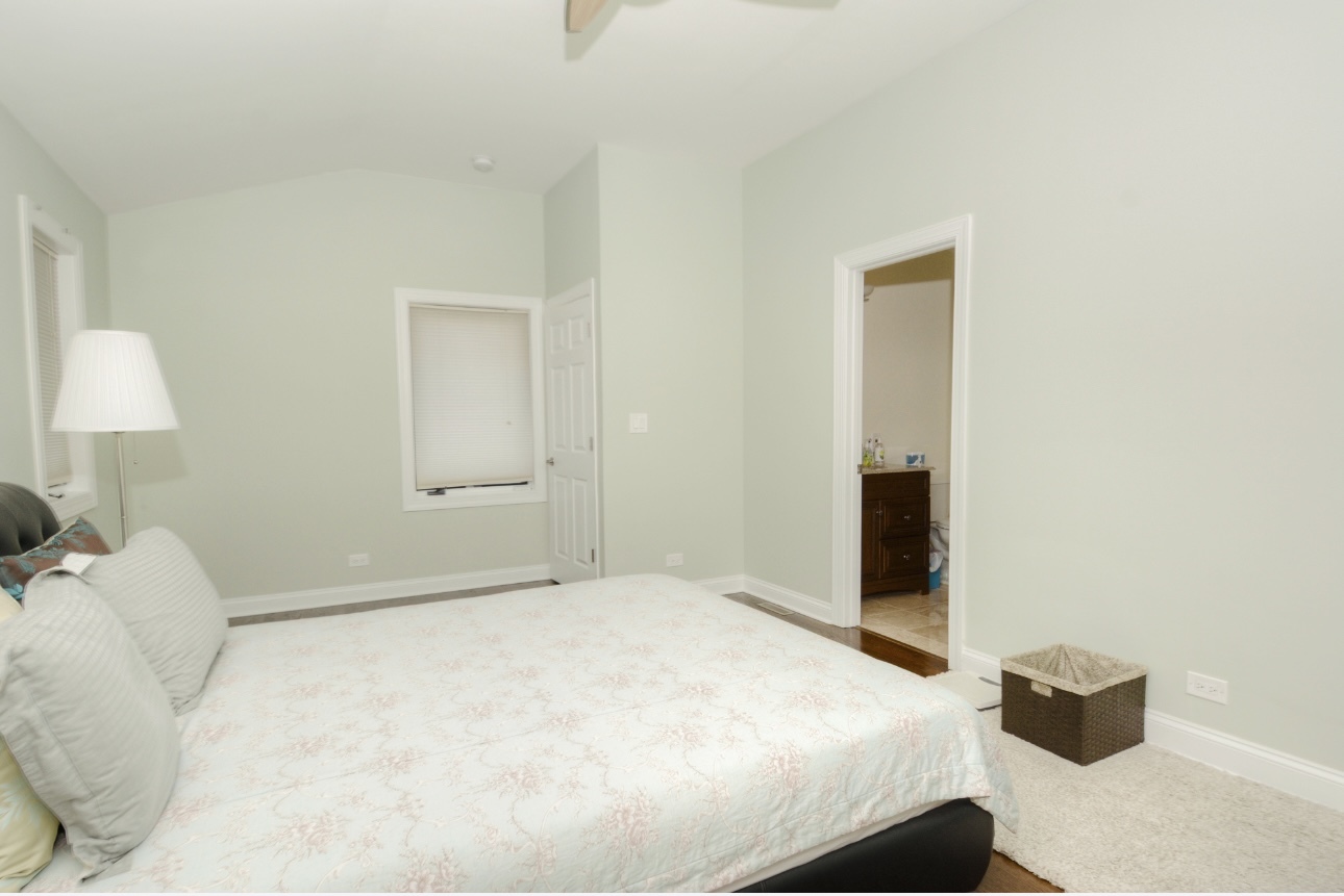 1115 Harms Road Glenview, IL 60025 - Photo 17 of 34 a bedroom with a bed and a lamp