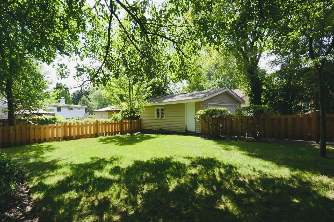 1115 Harms Road Glenview, IL 60025 - Photo 33 of 34 a backyard of a house with large trees and wooden fence
