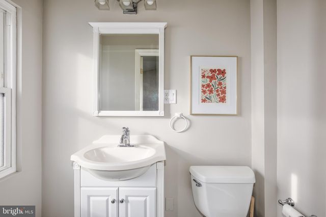 a bathroom with a toilet a sink and mirror