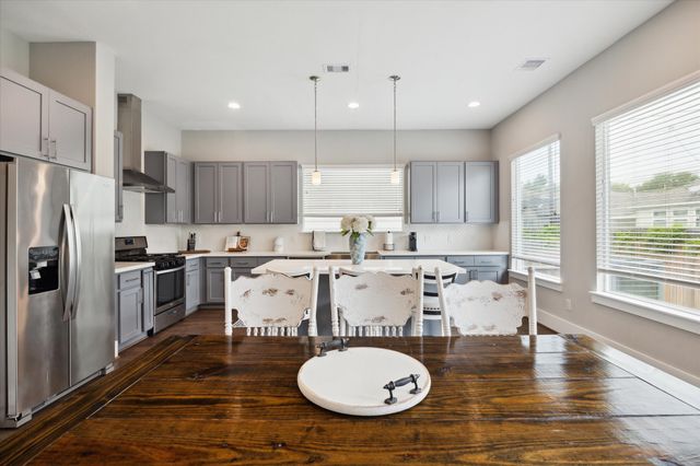 a kitchen with a table chairs stove and refrigerator