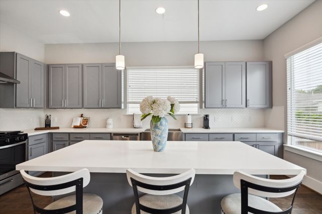 a kitchen with a dining table chairs and white appliances