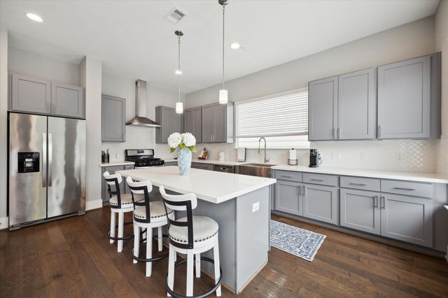a kitchen with a dining table chairs refrigerator and microwave