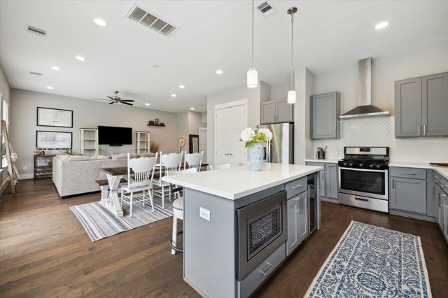 a open kitchen with stainless steel appliances kitchen island granite countertop a sink a stove and a refrigerator