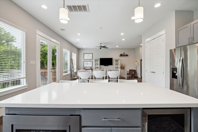 a large kitchen with a large counter top stainless steel appliances and windows