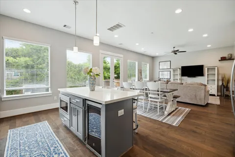 a kitchen with sink stove and white cabinets with wooden floor