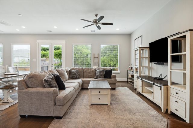 a living room with furniture flat screen tv and a large window