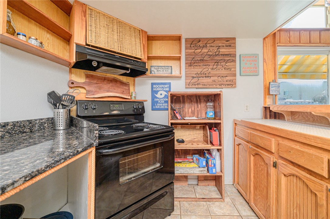 108 North 2nd Street Fulton, TX 78382 - Photo 14 of 23 a kitchen with stainless steel appliances granite countertop a stove and a microwave