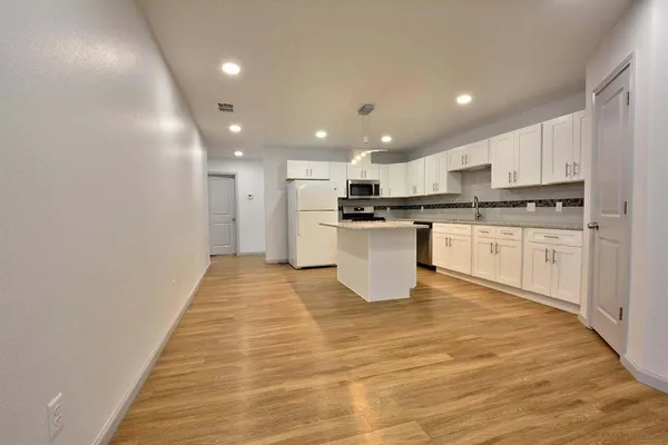 a view of kitchen with granite countertop lots of counter top space and cabinets