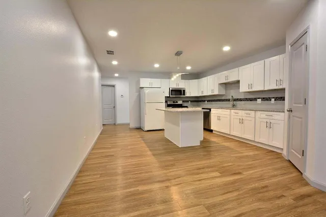a view of kitchen with granite countertop lots of counter top space and cabinets