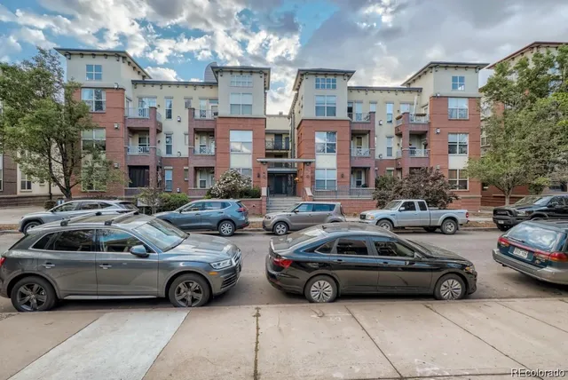 a view of a cars park in front of a building