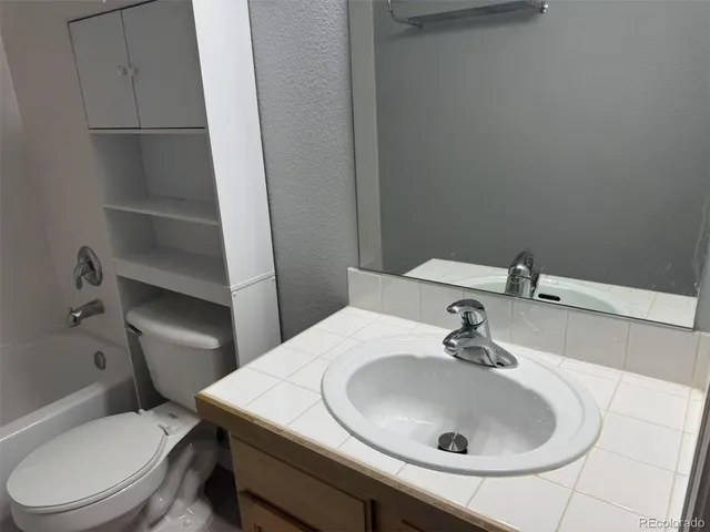 a bathroom with a sink toilet and a mirror