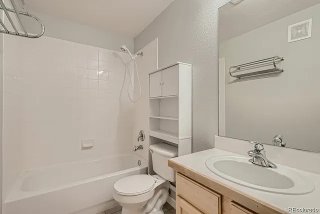 a bathroom with a sink toilet vanity and shower