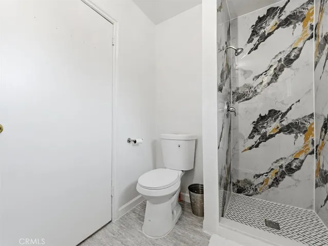 a bathroom with a toilet and a shower