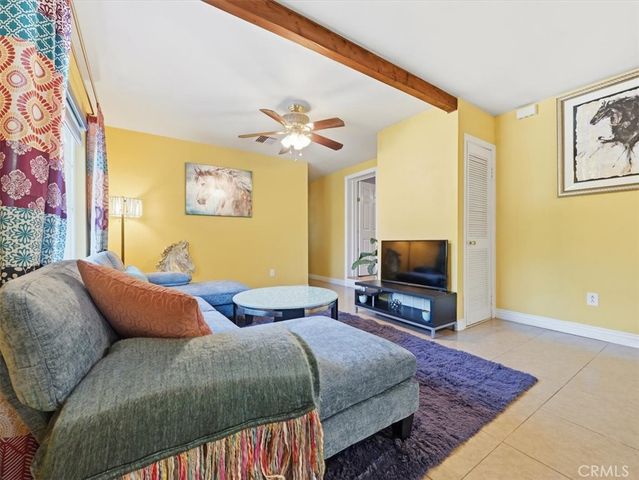 a bedroom with bed a couch and a flat screen tv