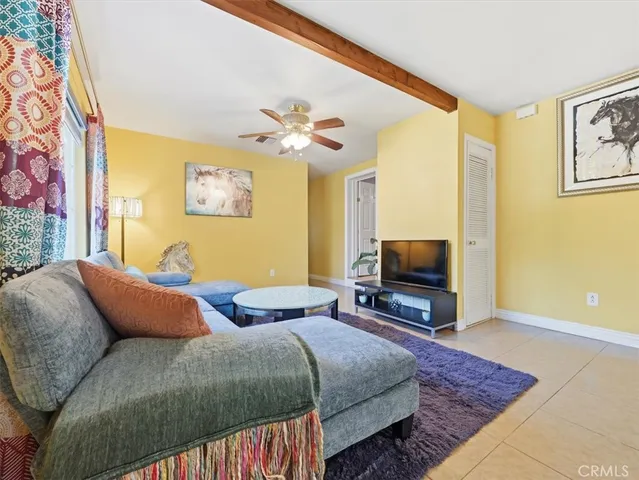 a bedroom with bed a couch and a flat screen tv
