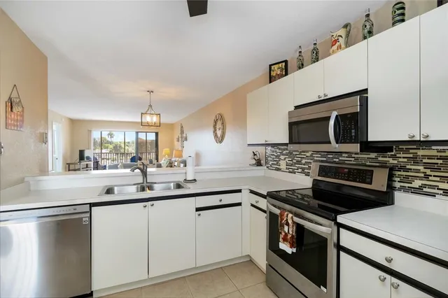 a kitchen with a sink stainless steel appliances and white cabinets