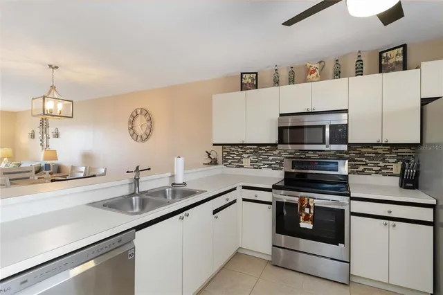 a kitchen with white cabinets and appliances