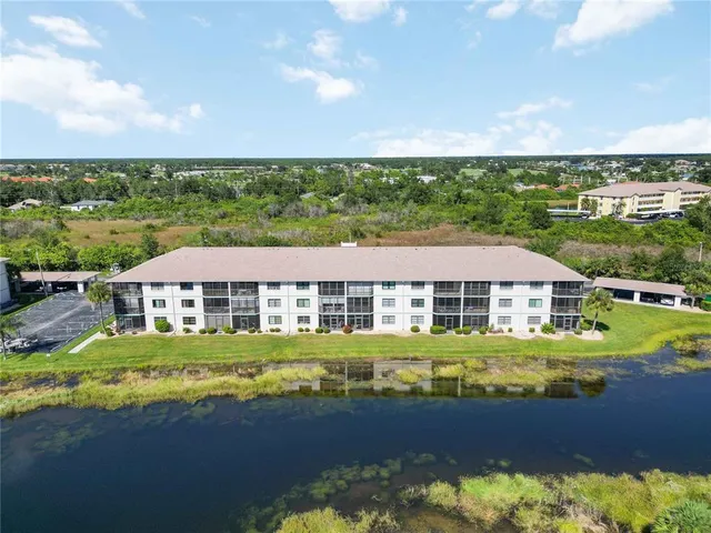 an aerial view of a house with a garden and lake view