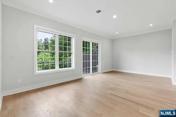 a kitchen with stainless steel appliances kitchen island granite countertop a refrigerator oven a stove and a sink with wooden floor