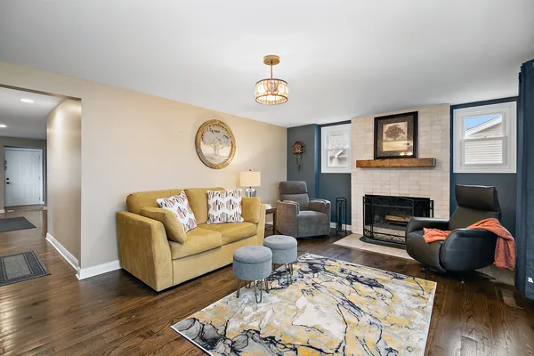 a living room with furniture a fireplace and wooden floor