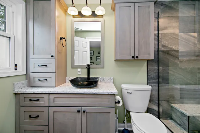 a bathroom with a granite countertop sink toilet and shower