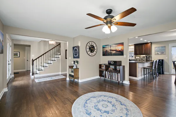 a view of a livingroom with furniture a ceiling fan and wooden floor