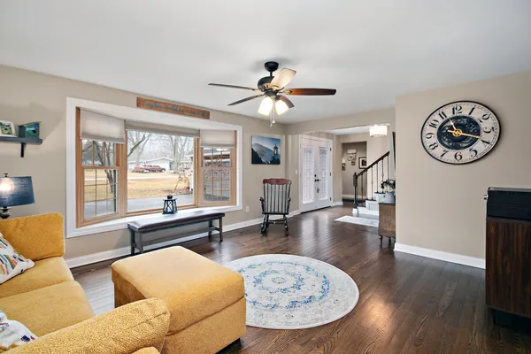 a living room with furniture a wooden floor and a chandelier