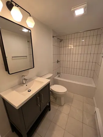 a bathroom with a sink a toilet and mirror