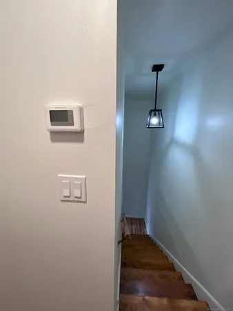 a view of a hallway with wooden floor and a ceiling fan