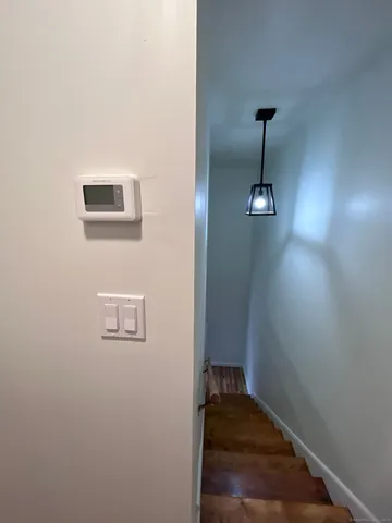 a view of a hallway with wooden floor and a ceiling fan