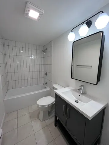 a bathroom with a sink mirror toilet and bathtub