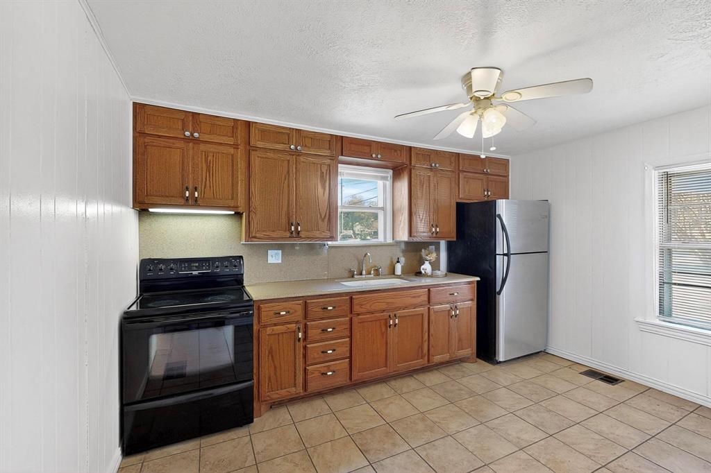 507 North Rusk Street Weatherford, TX 76086 - Photo 11 of 35 a kitchen with cabinets and window