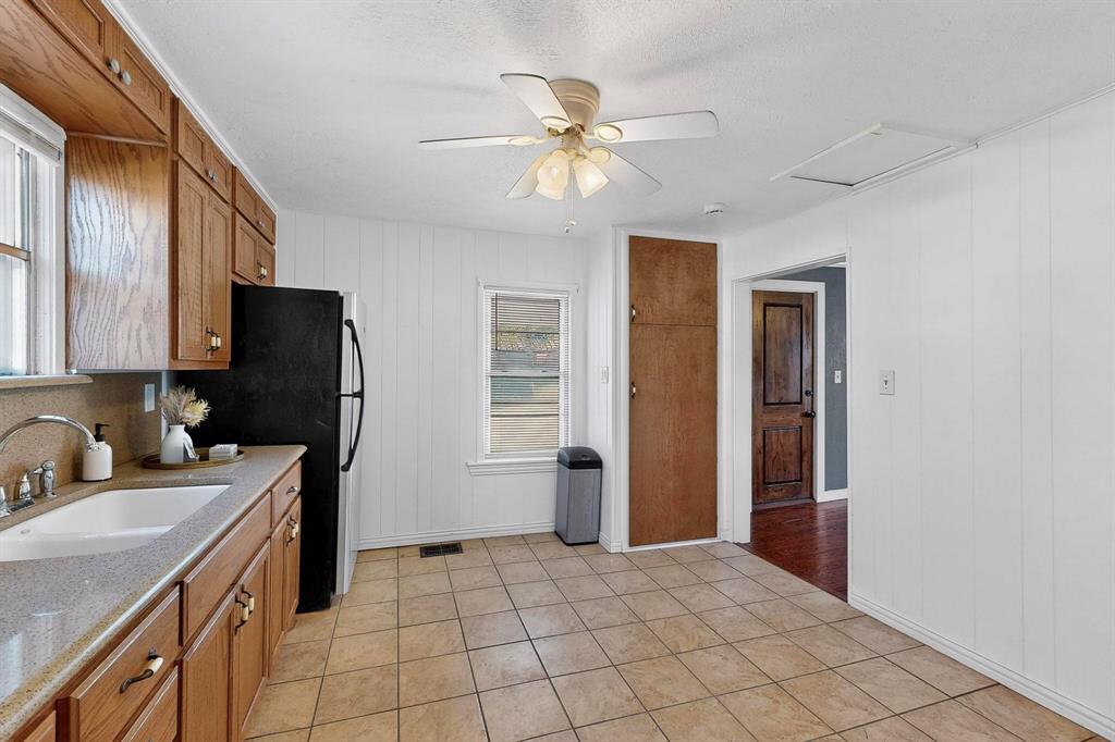 507 North Rusk Street Weatherford, TX 76086 - Photo 12 of 35 a kitchen with a refrigerator and a sink