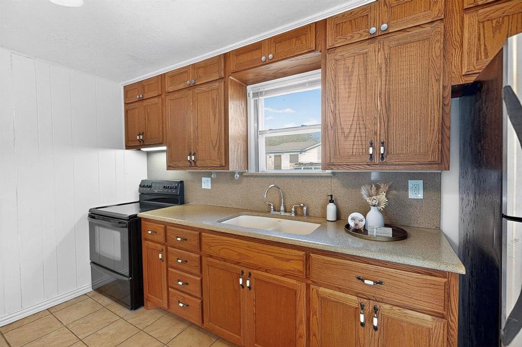 507 North Rusk Street Weatherford, TX 76086 - Photo 13 of 35 a kitchen with stainless steel appliances granite countertop a sink a stove and cabinets