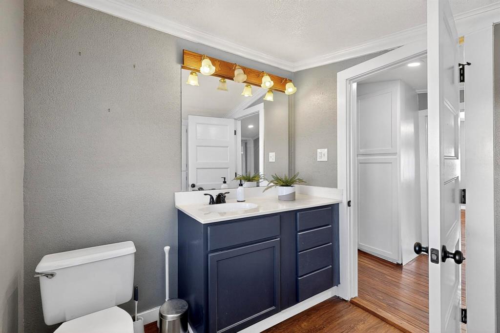 507 North Rusk Street Weatherford, TX 76086 - Photo 15 of 35 a bathroom with a toilet a sink and mirror