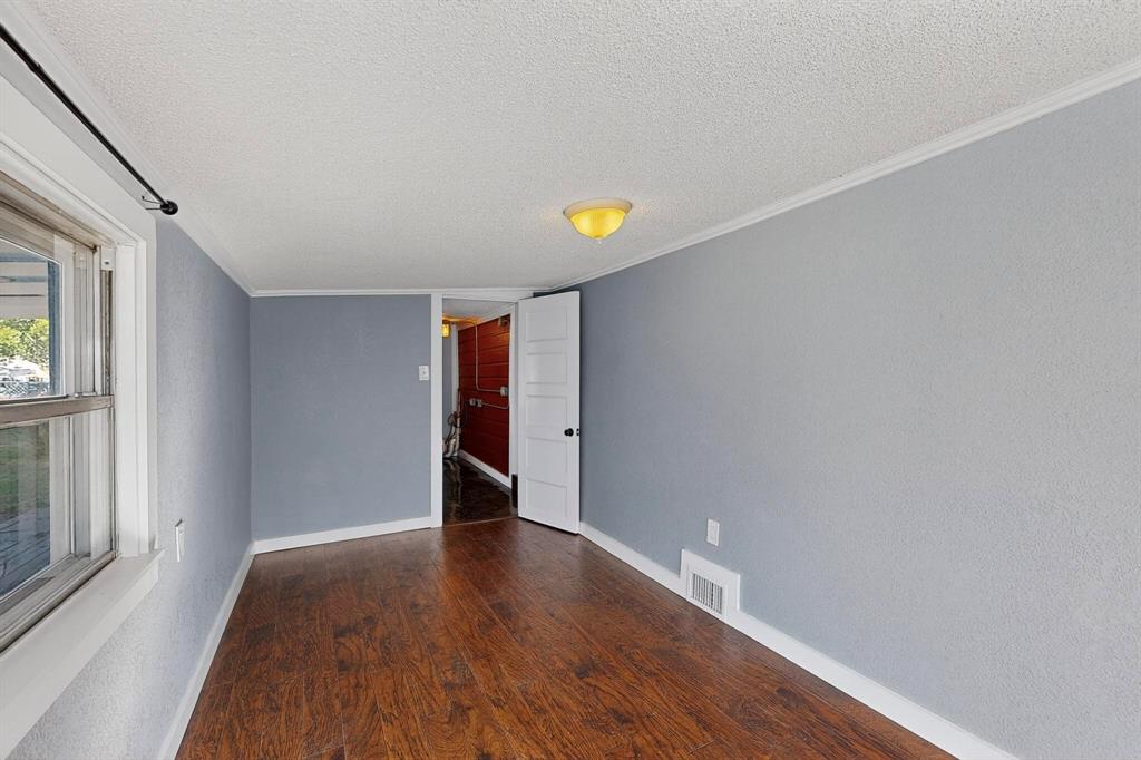 507 North Rusk Street Weatherford, TX 76086 - Photo 20 of 35 a view of an empty room with wooden floor and a window