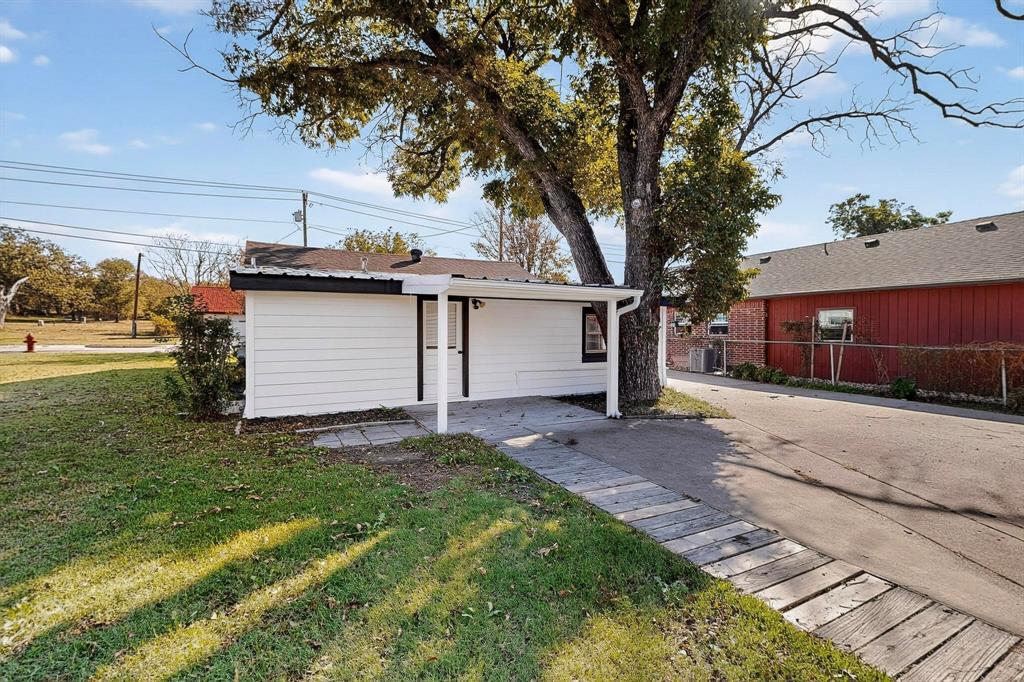 507 North Rusk Street Weatherford, TX 76086 - Photo 26 of 35 a front view of a house with a garden and yard
