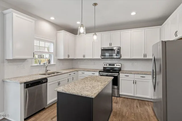 a kitchen with stainless steel appliances granite countertop a stove a sink and a refrigerator