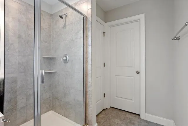 a bathroom with a shower and a glass door
