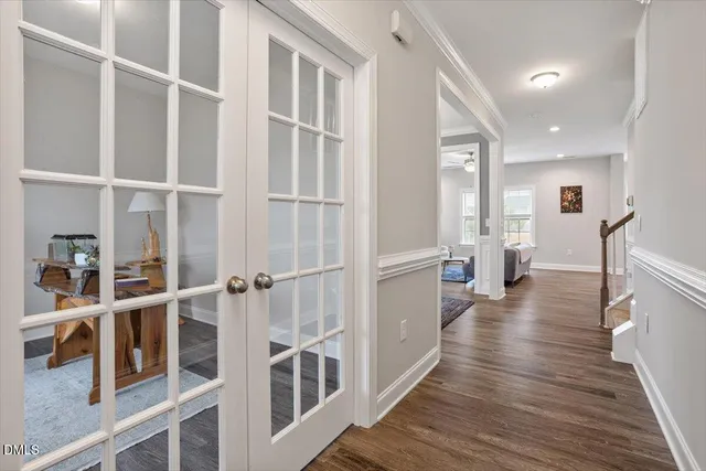 a view of a hallway with wooden floor and windows