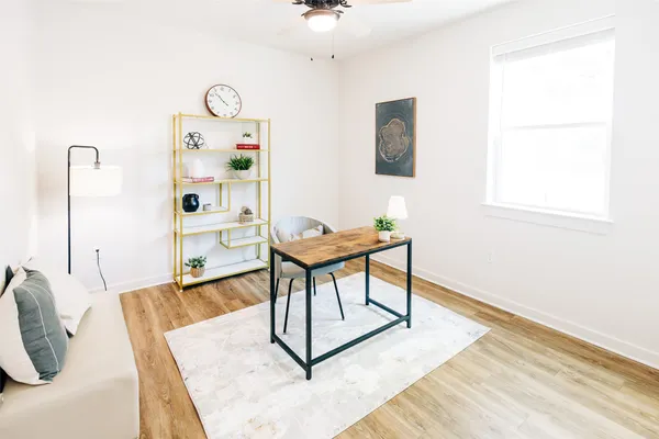 a bedroom with a bed and a dresser with rug