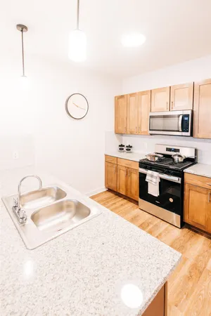 a kitchen with stainless steel appliances granite countertop a sink stove and cabinets