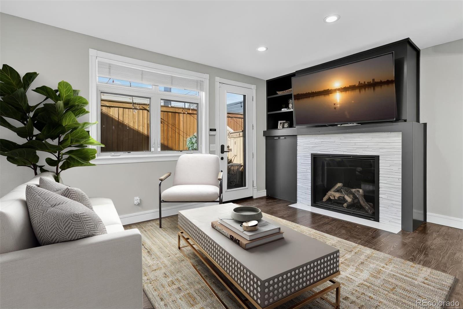 a living room with furniture a flat screen tv and a fireplace