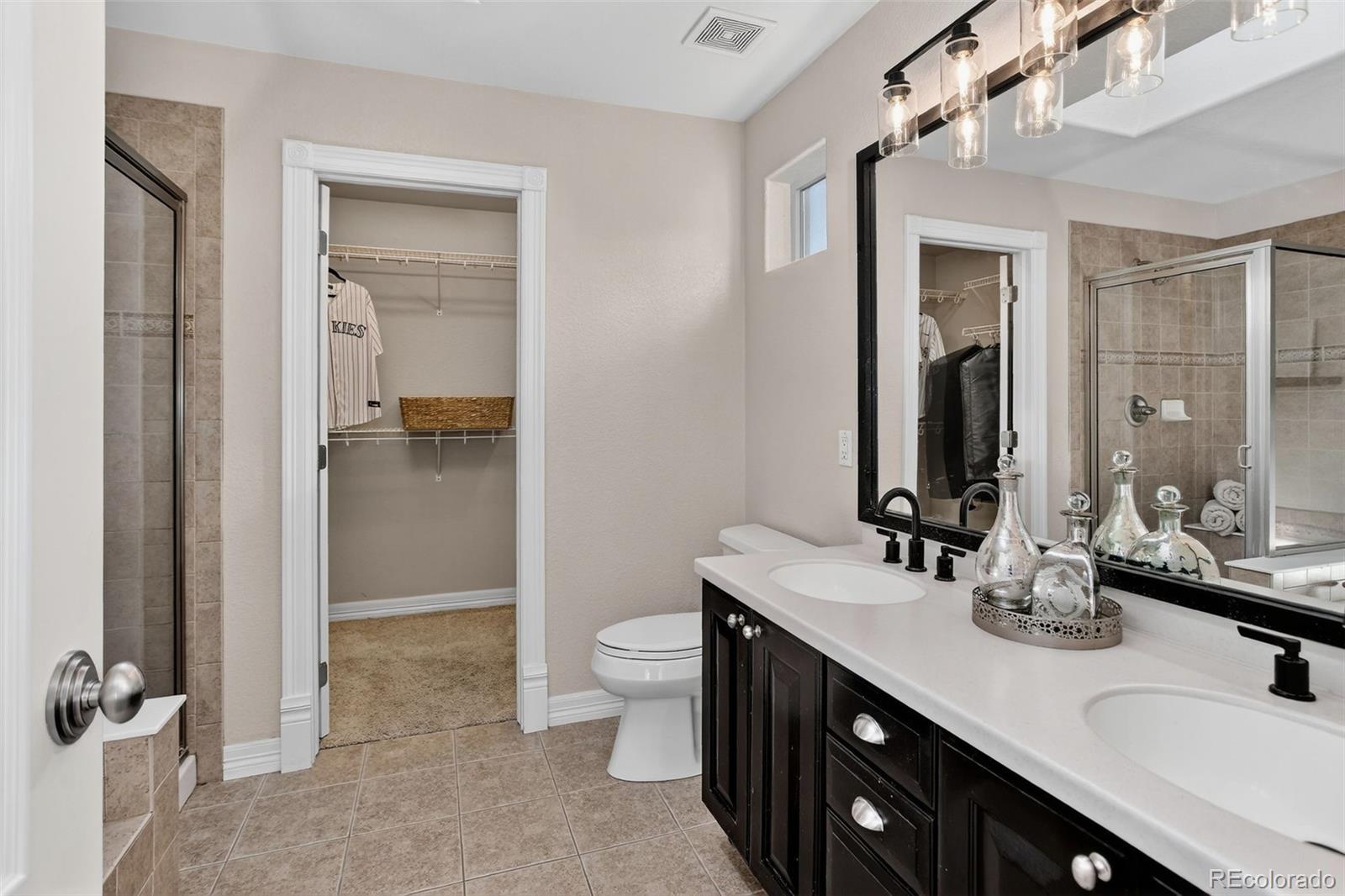 2311 Decatur Street Denver, CO 80211 - Photo 15 of 31 a bathroom with a double vanity sink a toilet and a mirror