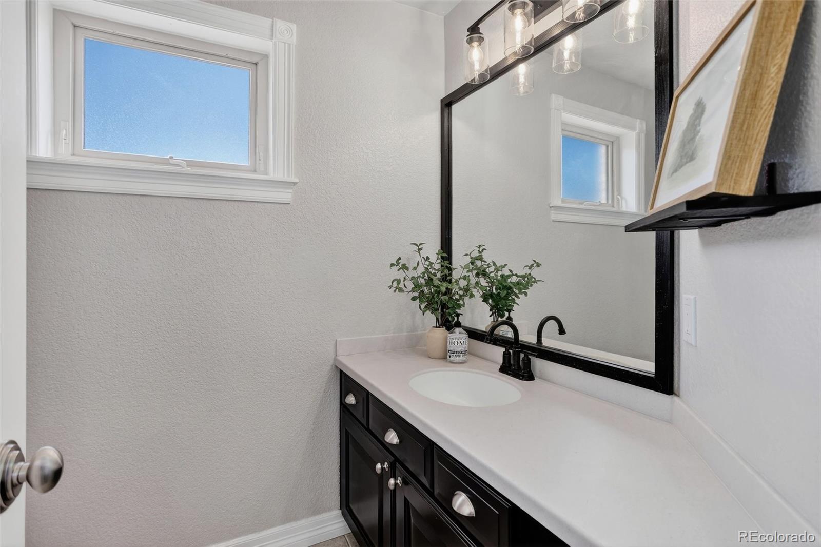 2311 Decatur Street Denver, CO 80211 - Photo 19 of 31 a bathroom with a sink and a mirror