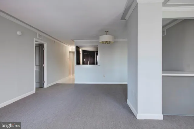 a view of a big room with wooden floor and windows